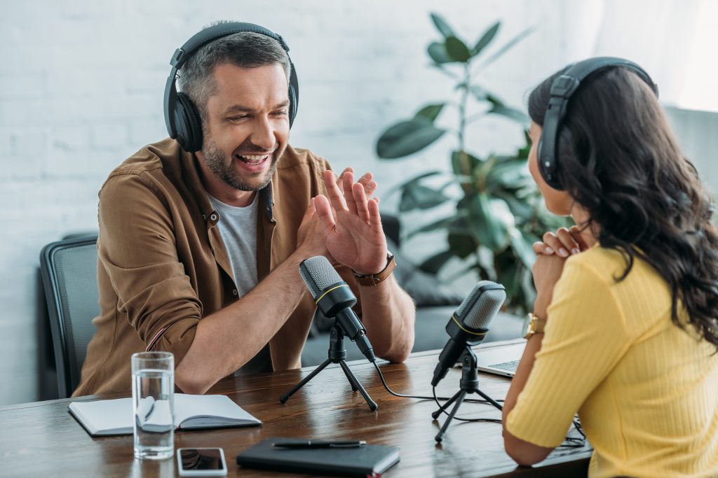 A man and woman recording a podcast