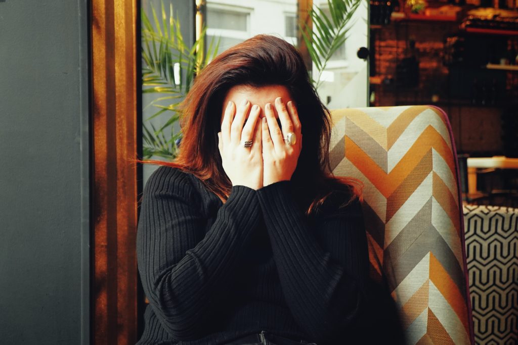 woman covering her face with her hands