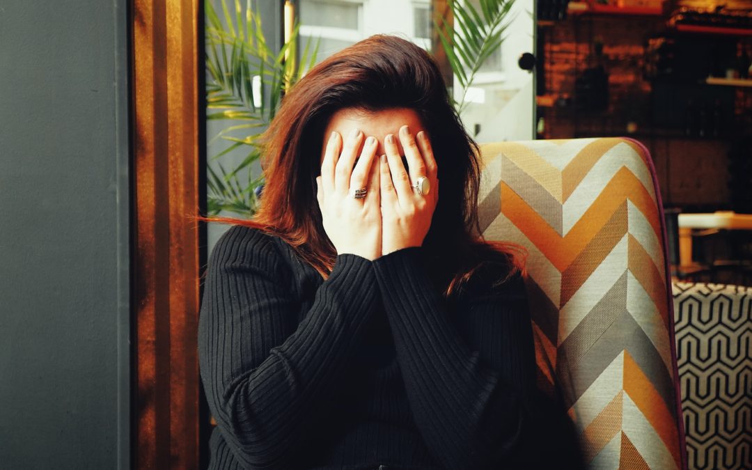 woman covering her face with her hands